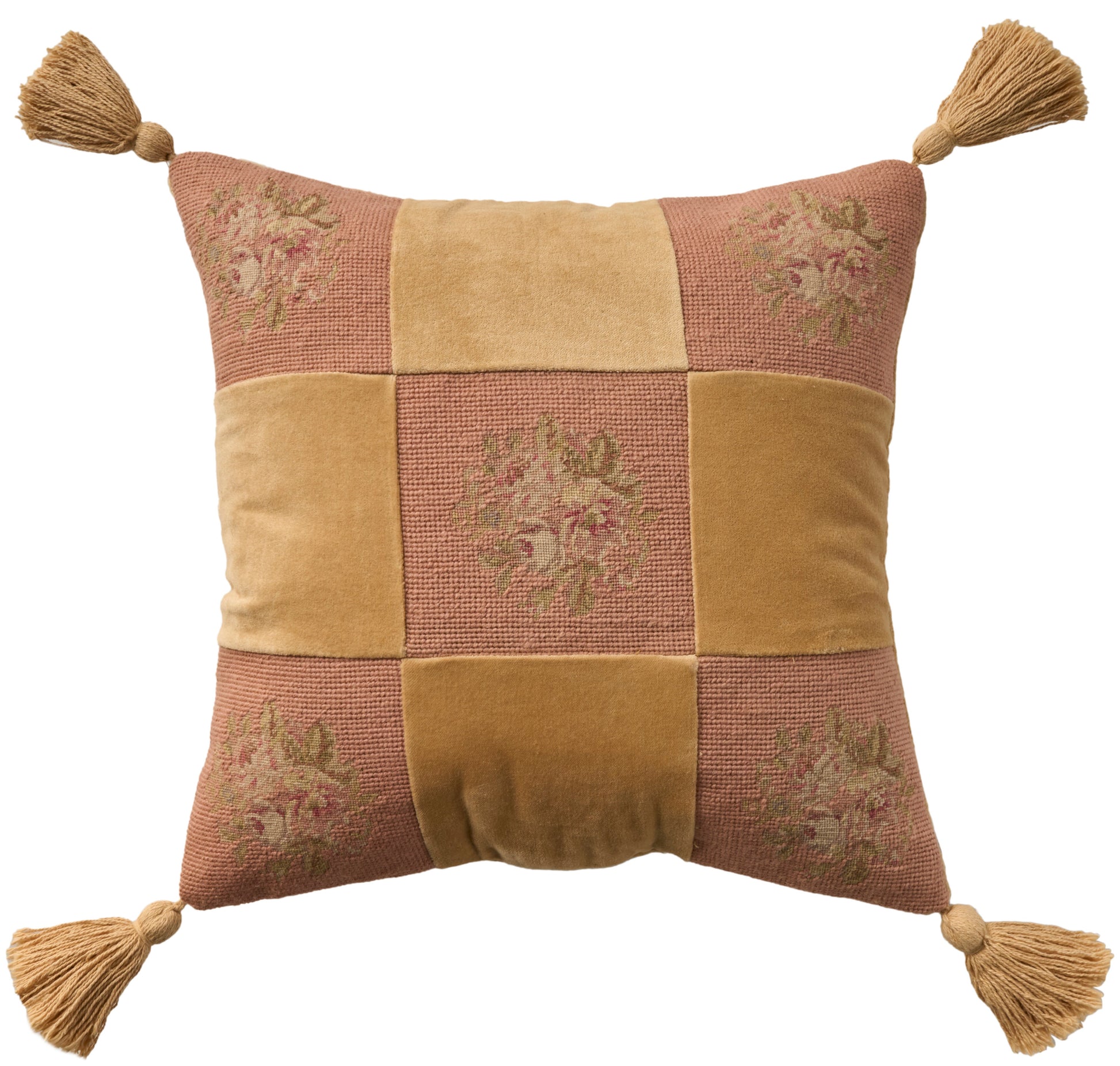 Decorative patchwork throw pillow with tassels at four corners; mustard yellow and dusty rose squares, floral embroidery.