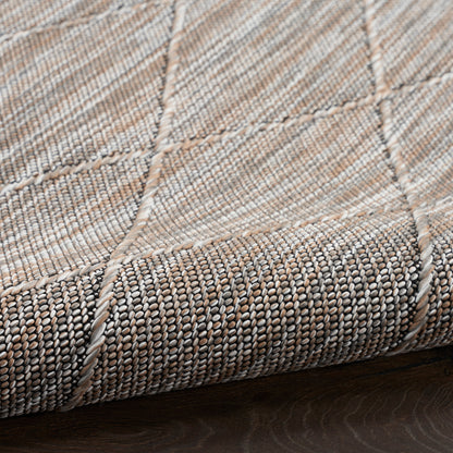 Beige-taupe woven rug with patchwork squares, stitched seams and textured looped weave.