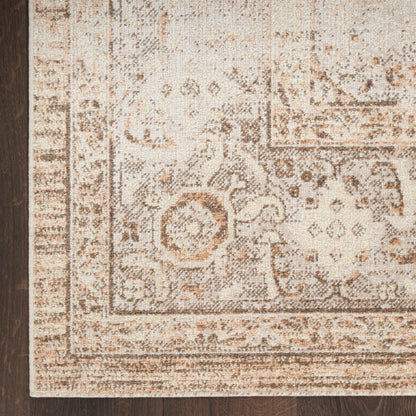 Cream-beige oriental rug with brown floral damask pattern and decorative border on dark hardwood floor.