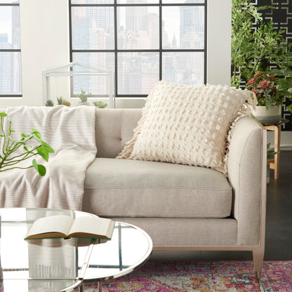 Cream farmhouse decorative pillow, textured fabric, 20" x 20", on a beige sofa.