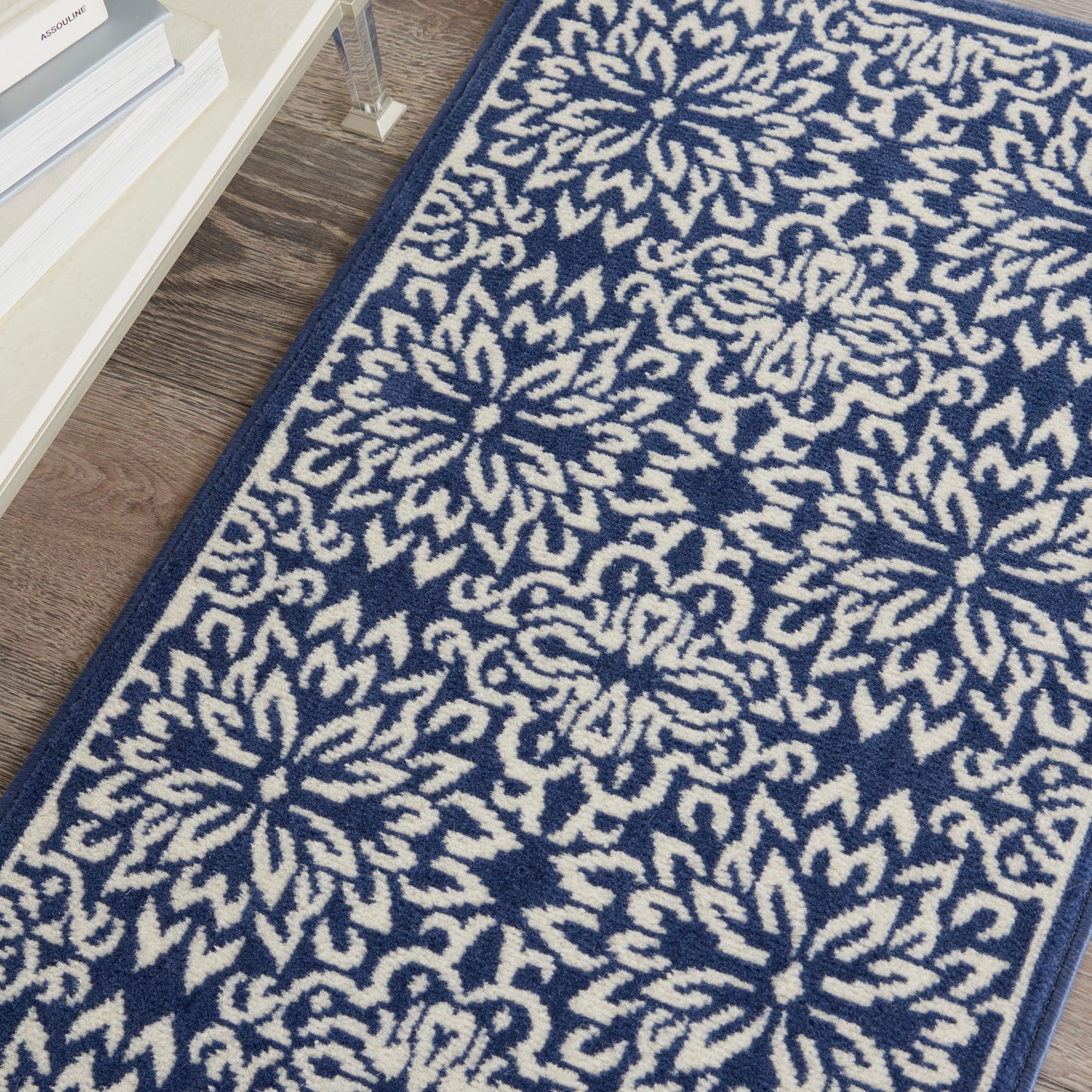 Navy blue and cream patterned rug with large floral medallion motifs, woven textile, blue border.
