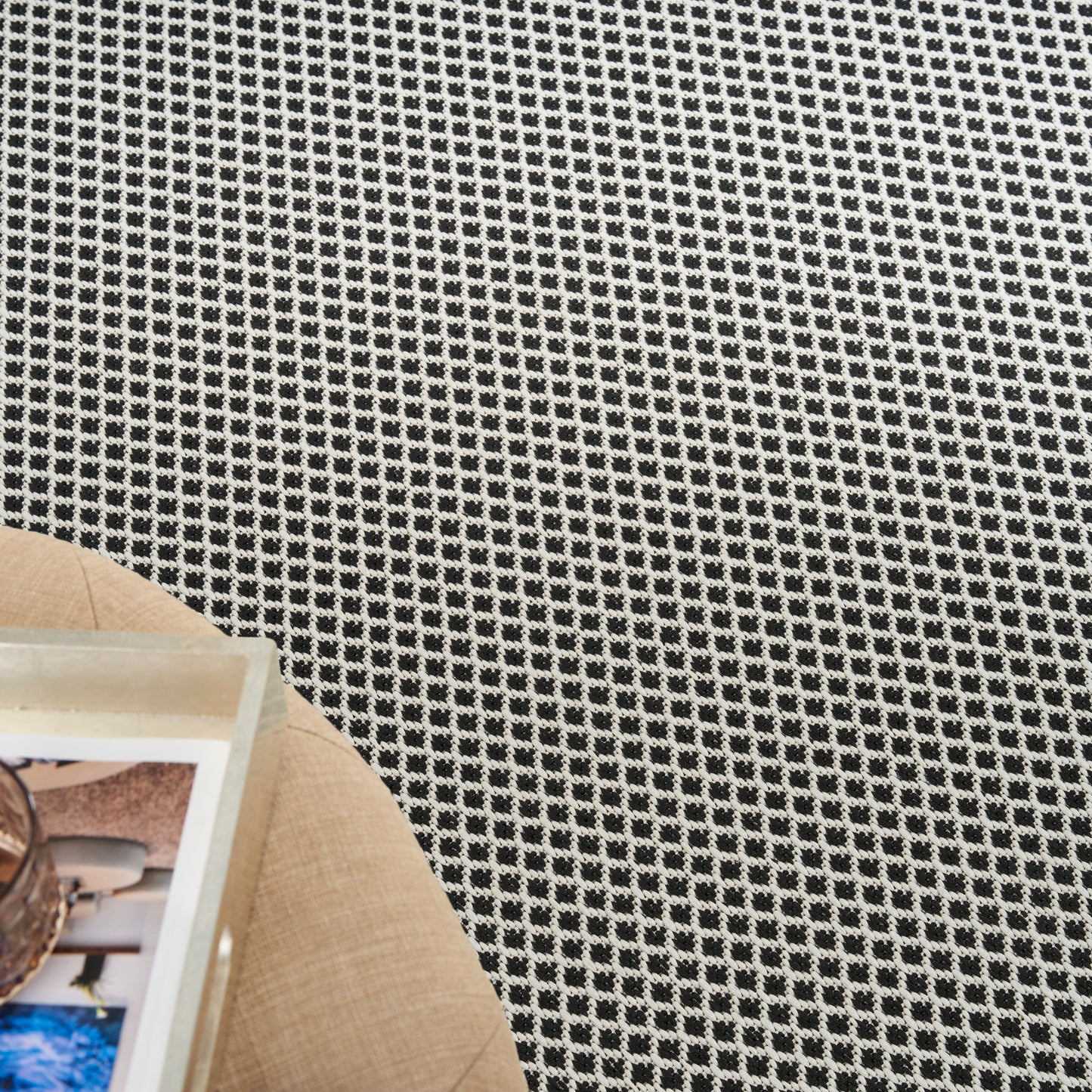 Black-and-white checkered woven rug texture on the floor.