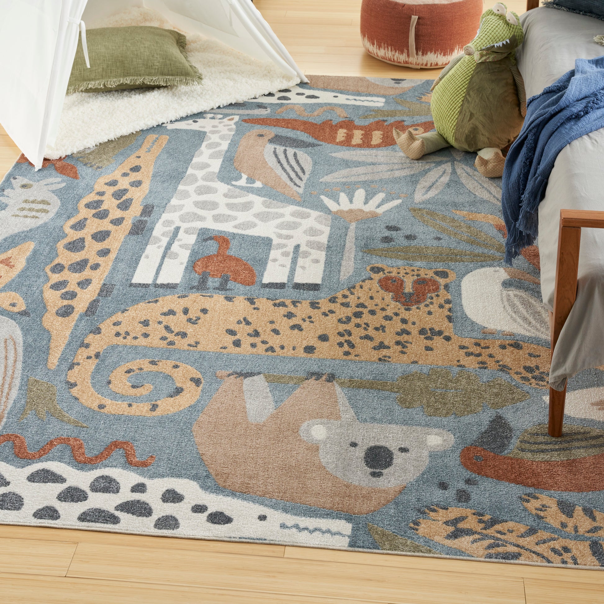 Colorful animal-print area rug in blue with giraffe and wildlife motifs, beige and white accents, ideal for a kids' room.