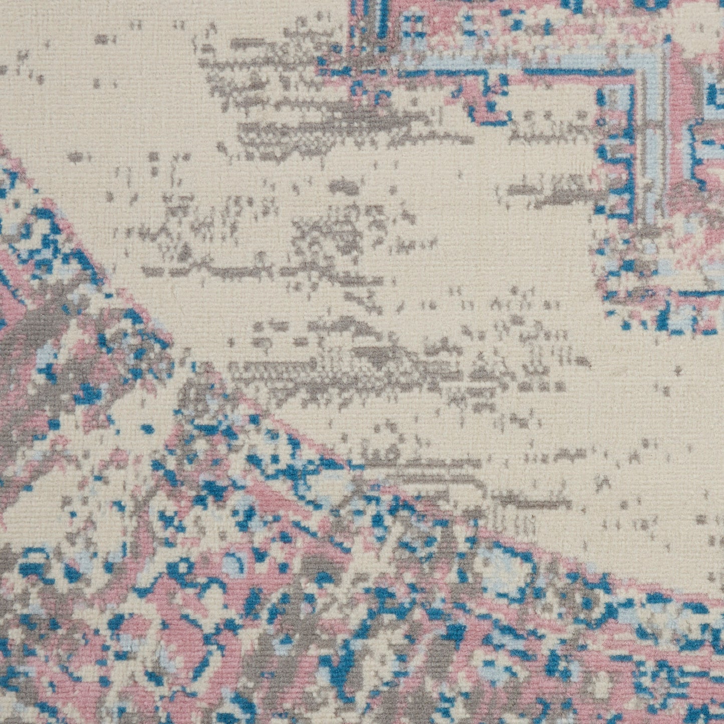 Woven beige area rug with faded pink and blue motifs, vintage oriental style.