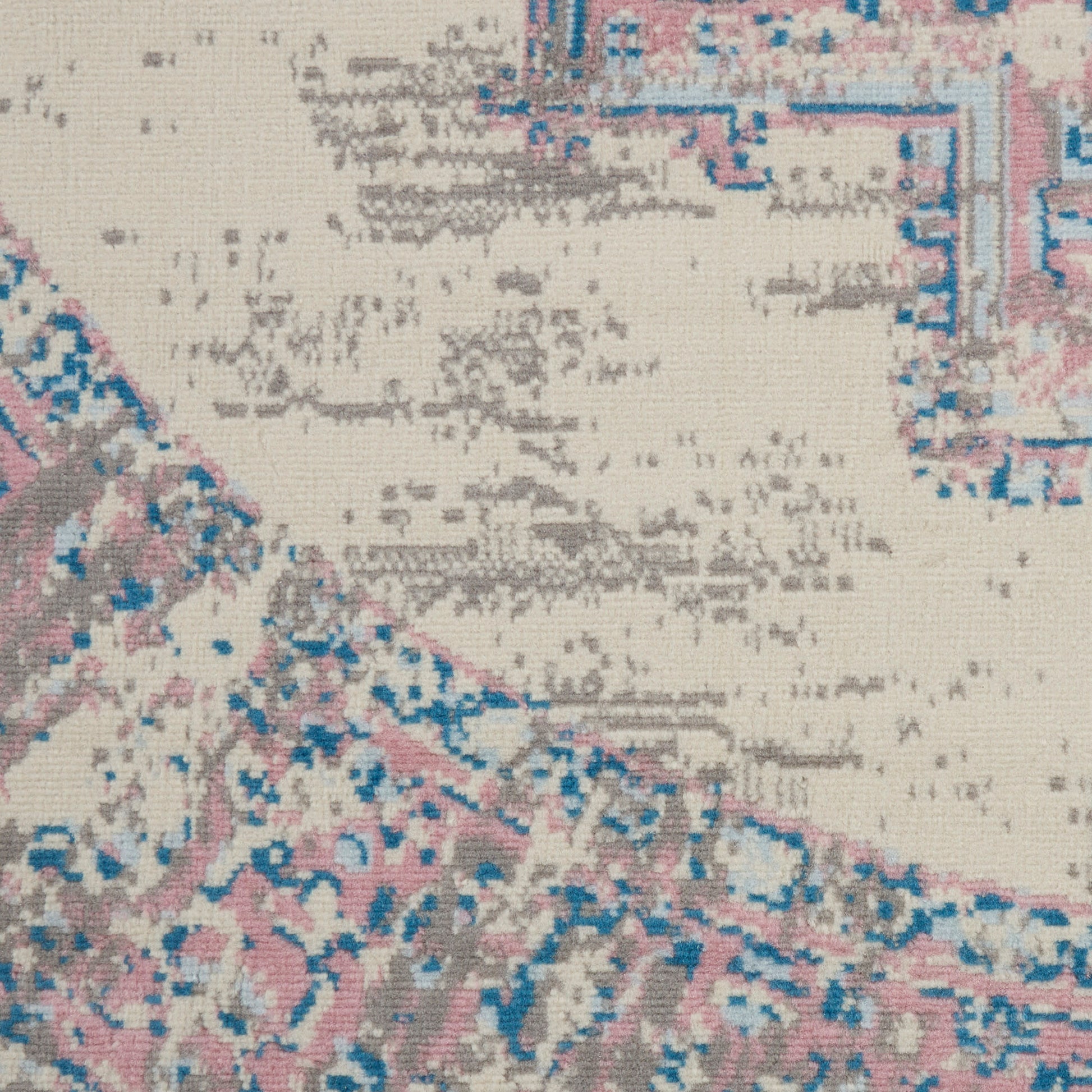 Woven beige area rug with faded pink and blue motifs, vintage oriental style.