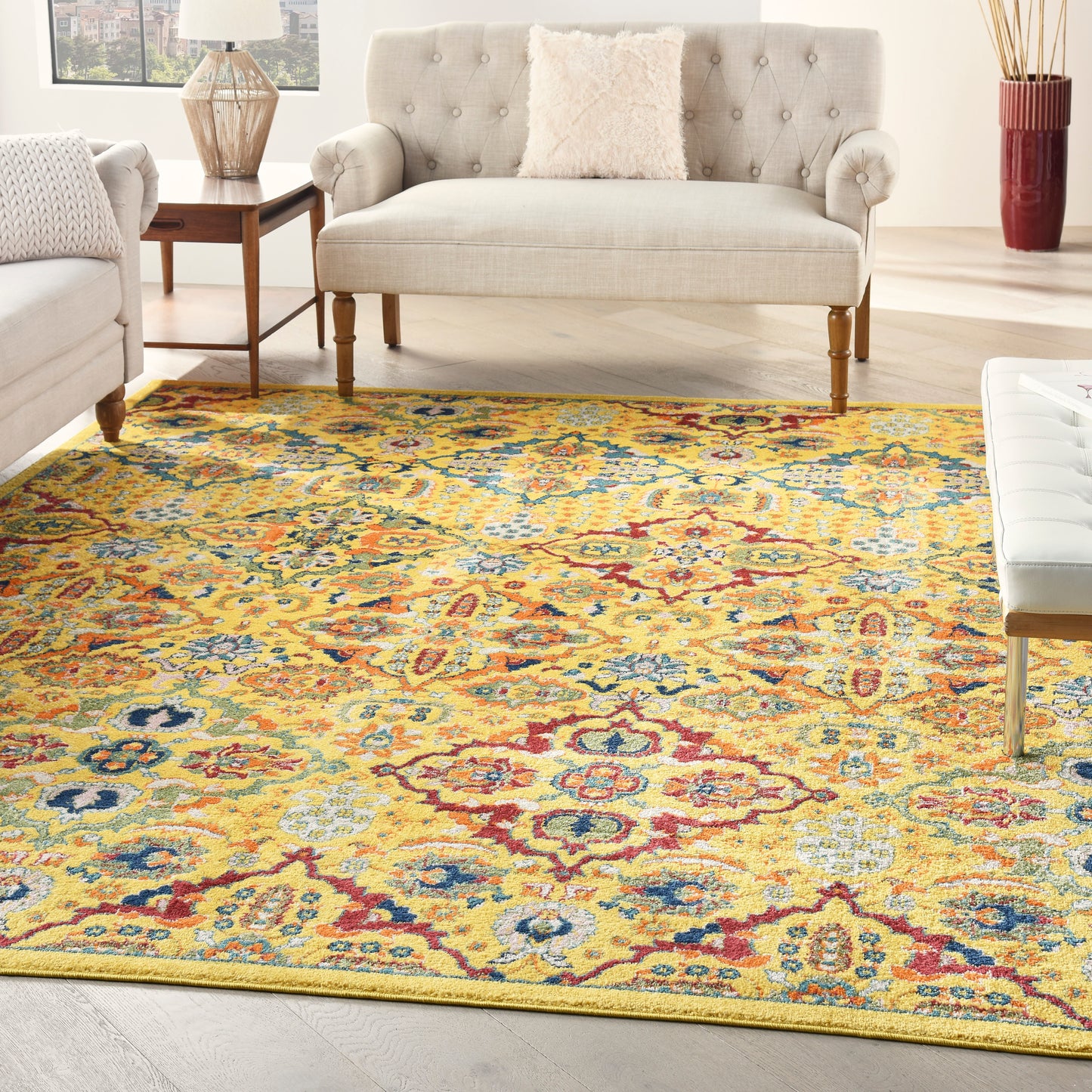 Bright living room with a yellow Oriental rug in multicolor floral pattern, beige tufted sofa, and light wood furnishings.