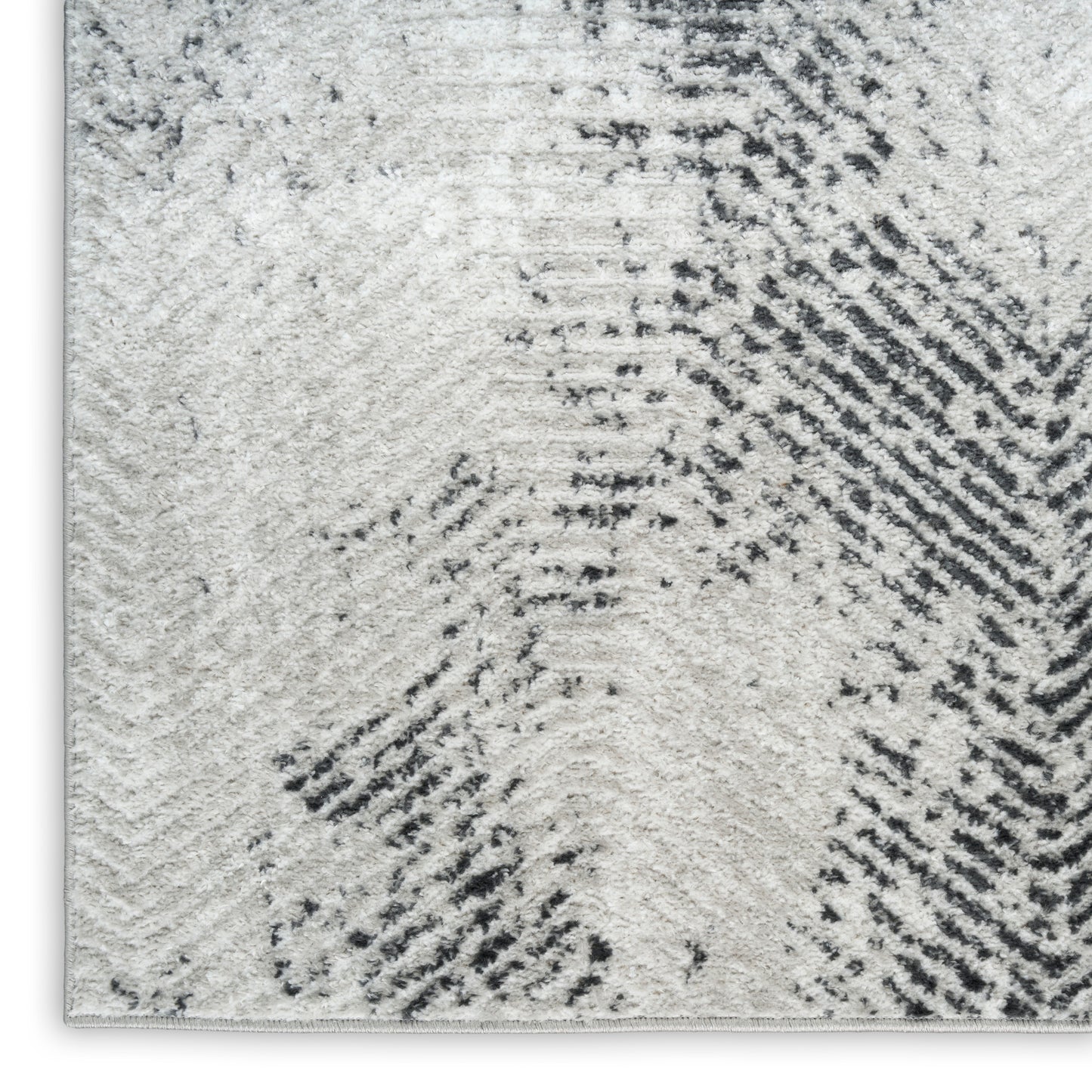 Cream-gray shag rug with abstract charcoal diagonal brushstroke pattern and soft textured pile.