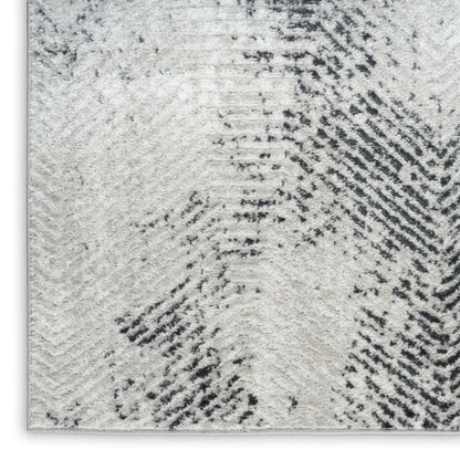 Cream-gray shag rug with abstract charcoal diagonal brushstroke pattern and soft textured pile.
