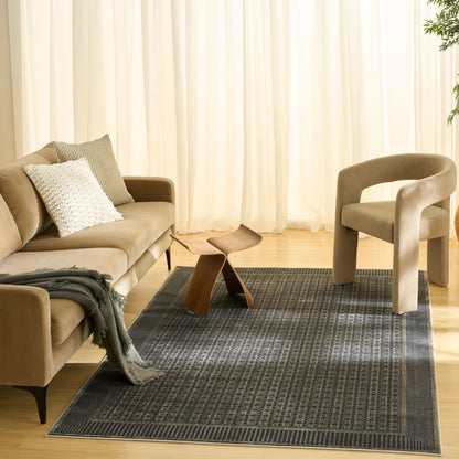 Blue-grey Art Deco rug (5' x 7') on the floor in a neutral living room setting.