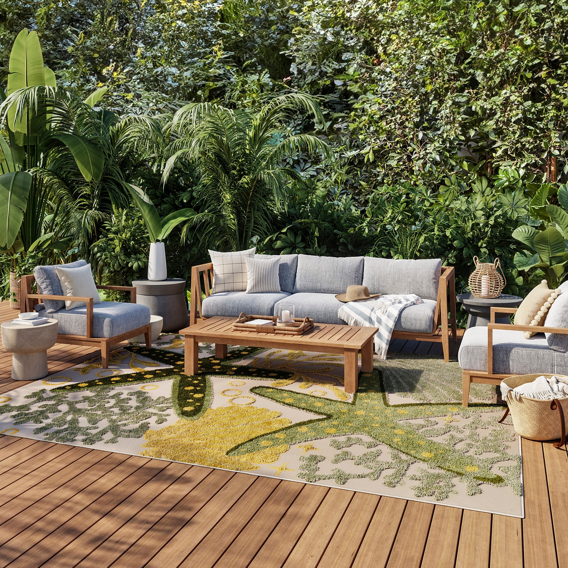 Outdoor rug 6' x 9' with a green-yellow pattern amid tropical plants.