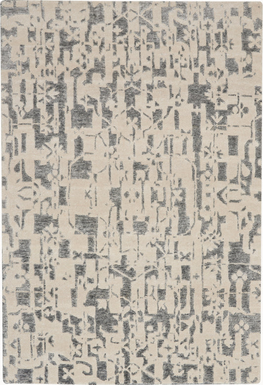 Beige area rug with an abstract charcoal gray distressed pattern; rectangular, soft woven texture.