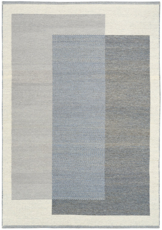 Abstract area rug with overlapping vertical rectangles in cream, light gray, blue-gray and charcoal, woven texture.