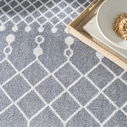 Gray rug with white geometric lattice pattern; woven rattan tray with a white bowl of granola.