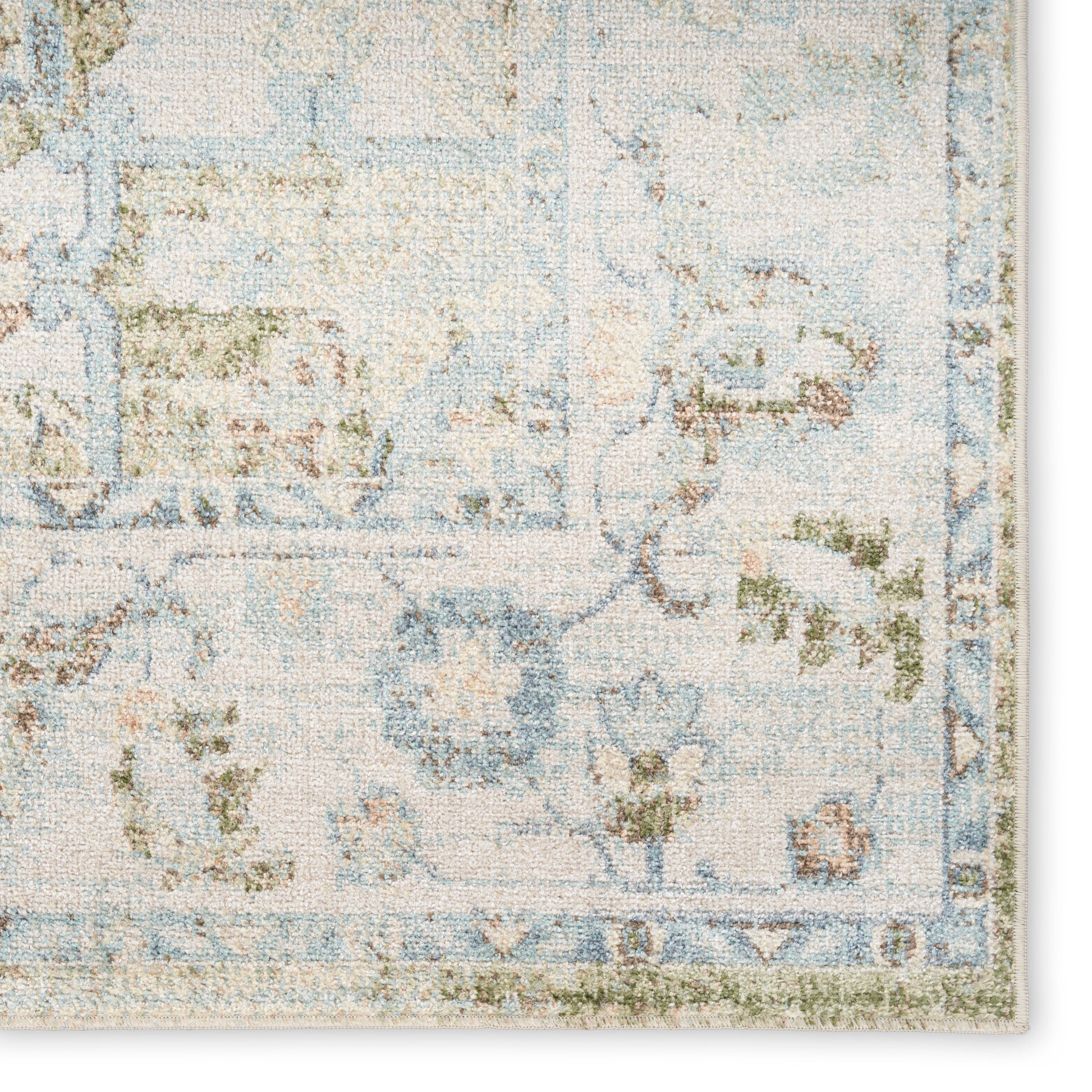Pastel blue and cream floral area rug with subtle green accents and an ornate border.