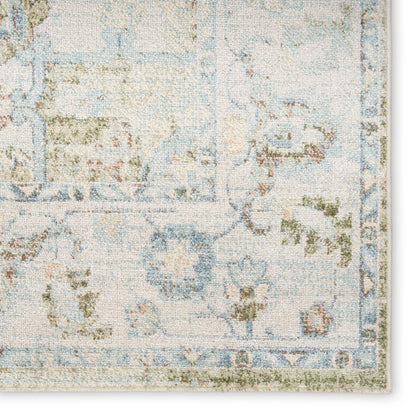 Pastel blue and cream floral area rug with subtle green accents and an ornate border.