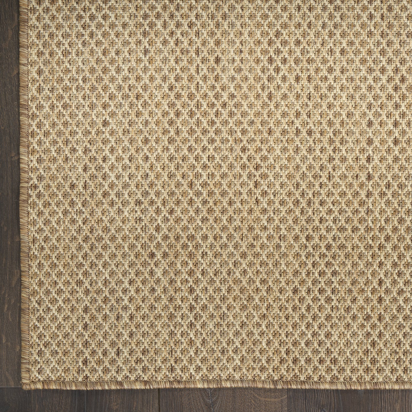 Natural jute runner rug with beige-brown diamond weave and fringed edge, on a dark wood floor, 10 ft long.