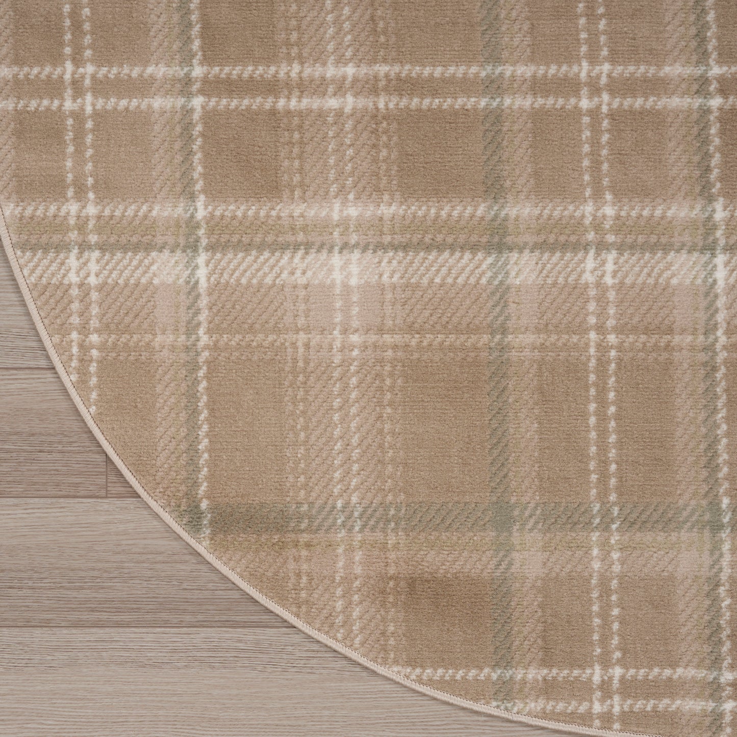 Beige plaid round rug with white and sage green stripes; plush texture on wooden floor.
