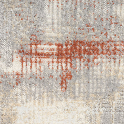 Close-up of a textured rug with gray, cream, beige and rust orange abstract pattern and textured pile.