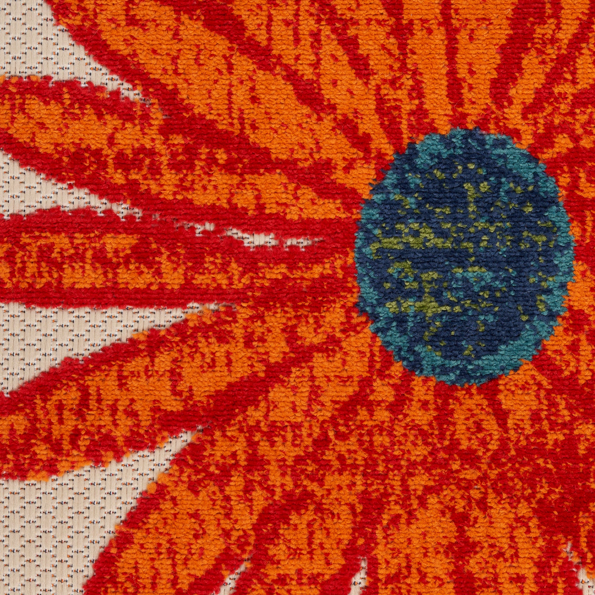 Vibrant orange daisy-pattern rug close-up with a blue-green center on beige woven backdrop; textured carpet.
