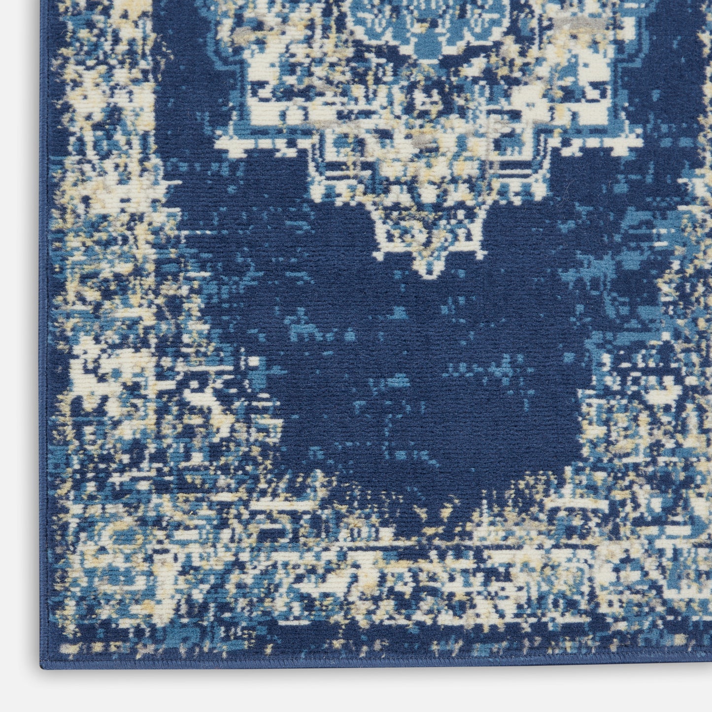 Distressed navy blue area rug with ivory antique medallion motif and blue border, vintage Persian-inspired design.