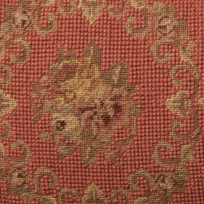 Red woven rug with gold floral medallion and scrolling border; textured textile.