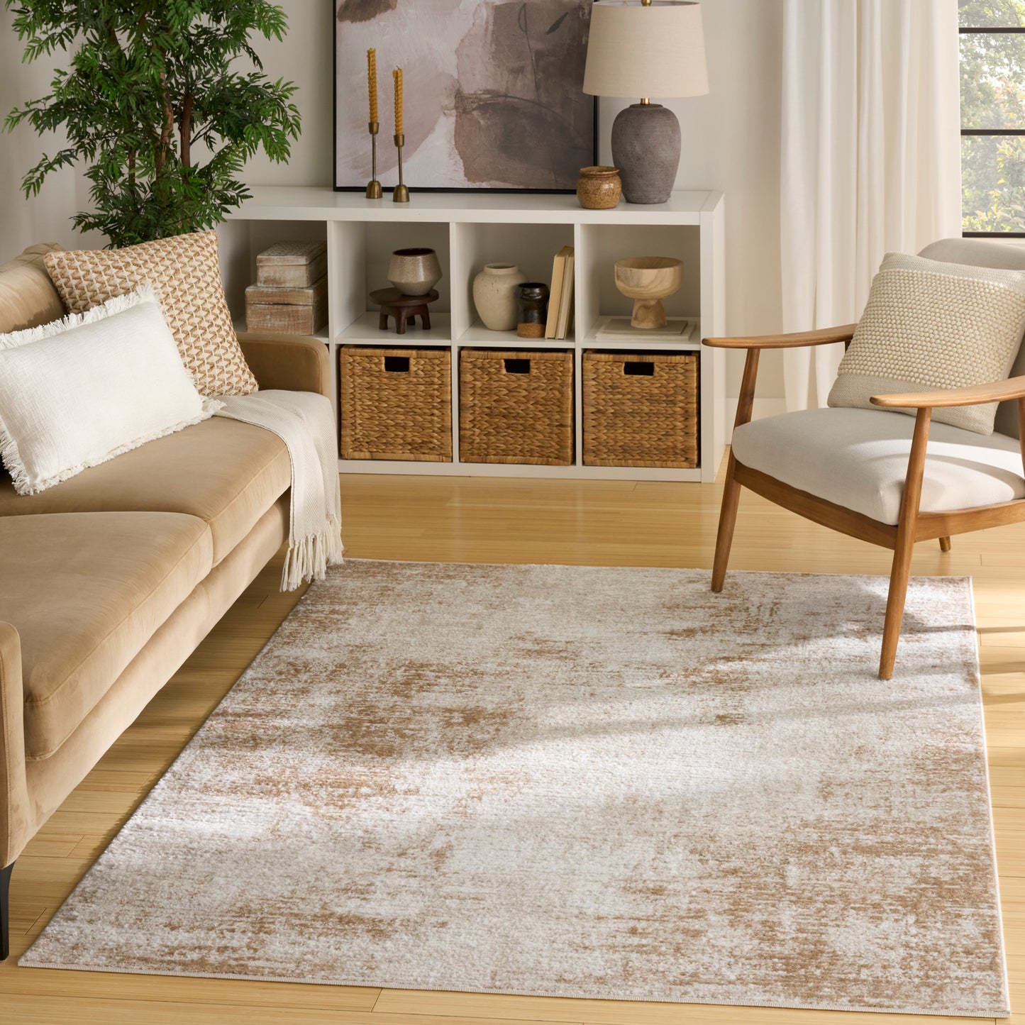 Neutral living room with beige sofa, mid-century armchair, light wood floors, rug, white cubby storage and wicker baskets.