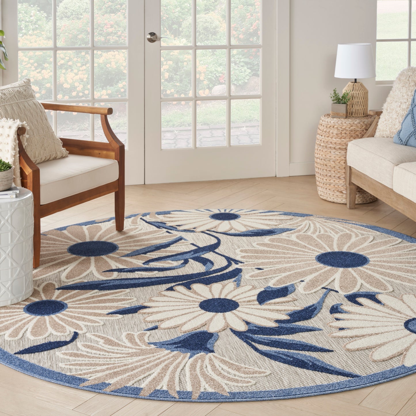 Round beige floral area rug with navy blue flowers and border; woven texture for coastal living room.