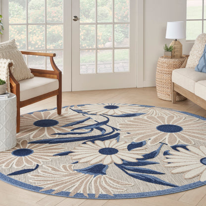 Round beige floral area rug with navy blue flowers and border; woven texture for coastal living room.