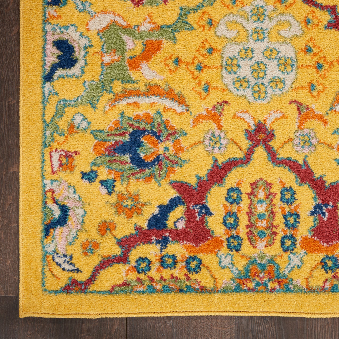 Rectangular oriental area rug with a yellow field, blue and red floral motifs, teal accents, and a gold border.