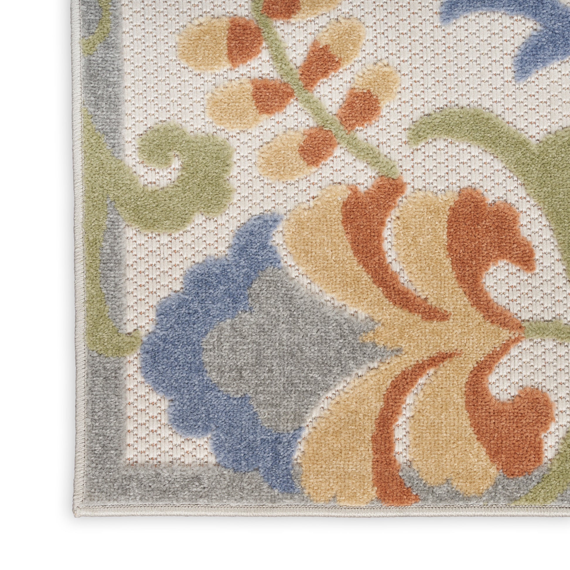 Close-up of a tufted floral area rug with beige base and blue, orange, yellow and green petals and a light gray border.