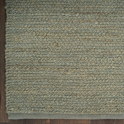Green-gray woven loop-pile rug with natural fiber look, bound edge; ideal for entryway or living room.