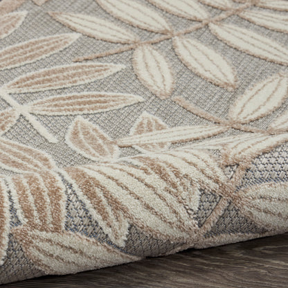 Beige leaf-pattern rug on gray backdrop; textured woven pile with cream and tan leaves.