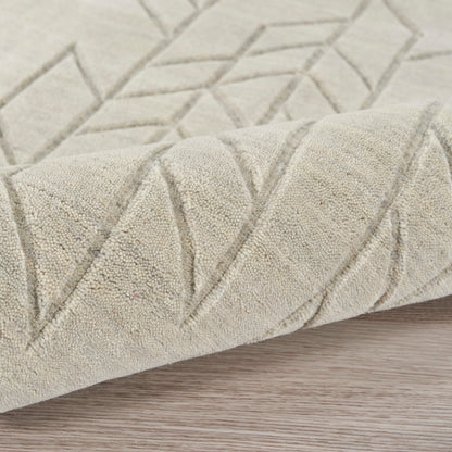 Beige flat-weave rug with geometric chevron and diamond pattern, soft textured pile, rolled edge on wood floor.