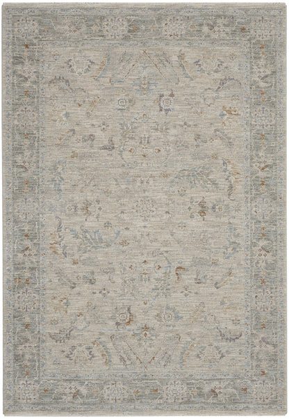 Soft distressed area rug in muted gray-beige with pale blue floral motifs and ornate border, traditional Oriental style.