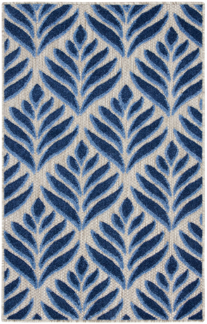 Rectangular tufted rug with navy blue fern-like leaf motifs on a beige woven ground; modern botanical decor for living room.