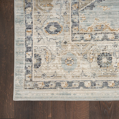 Rectangular distressed blue, ivory, and beige oriental runner with an ornate border on dark wood floor.
