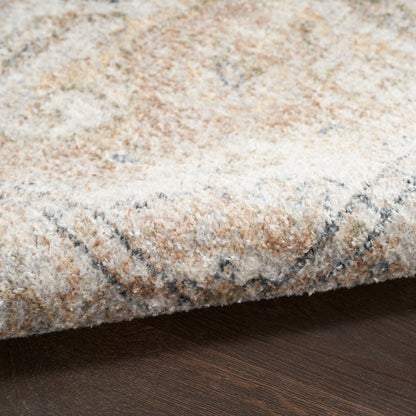Close-up of plush beige ivory rug with subtle gray geometric pattern on dark wood floor.