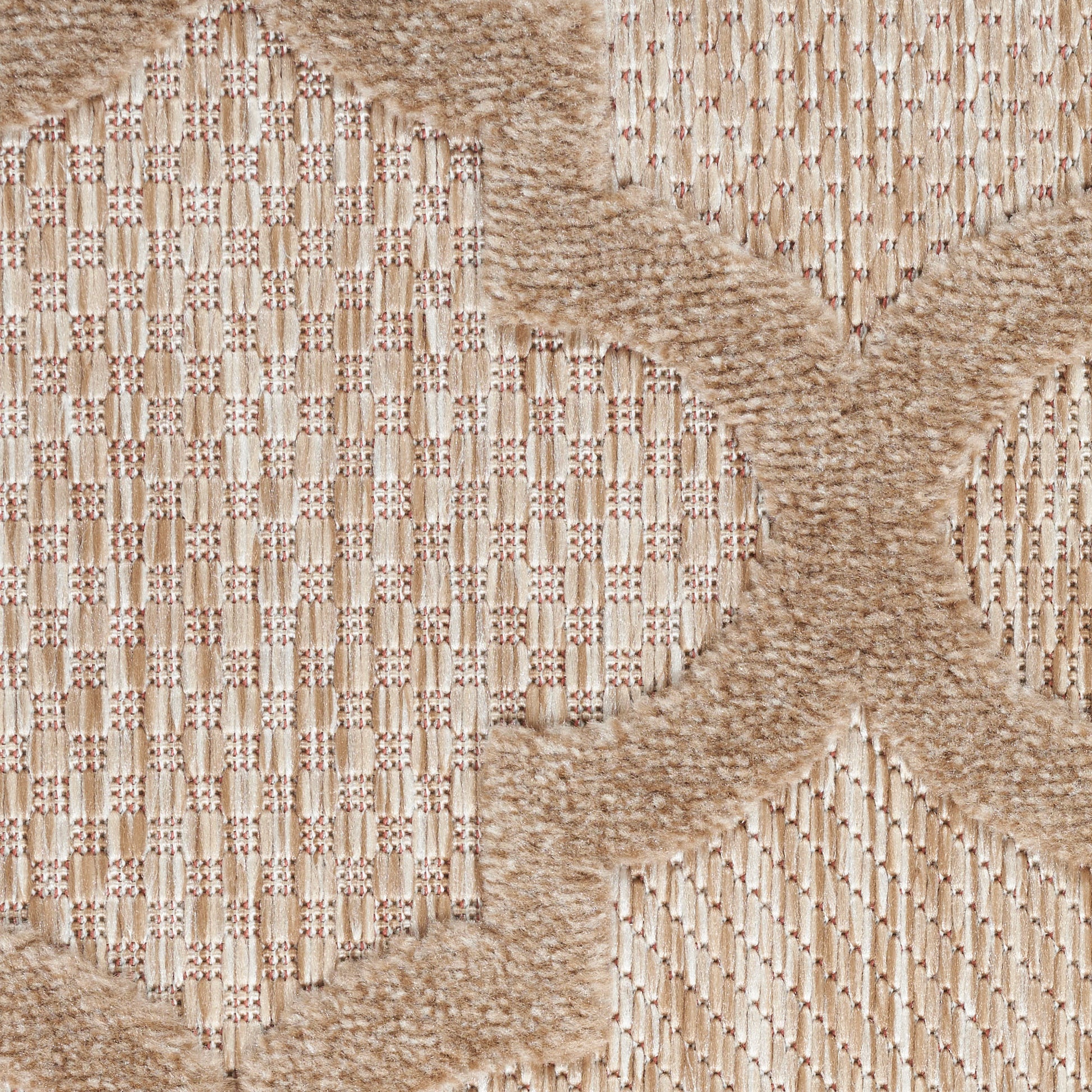 Beige shaggy rug with tan X-shaped motifs on a woven striped background; warm, textured floor covering.