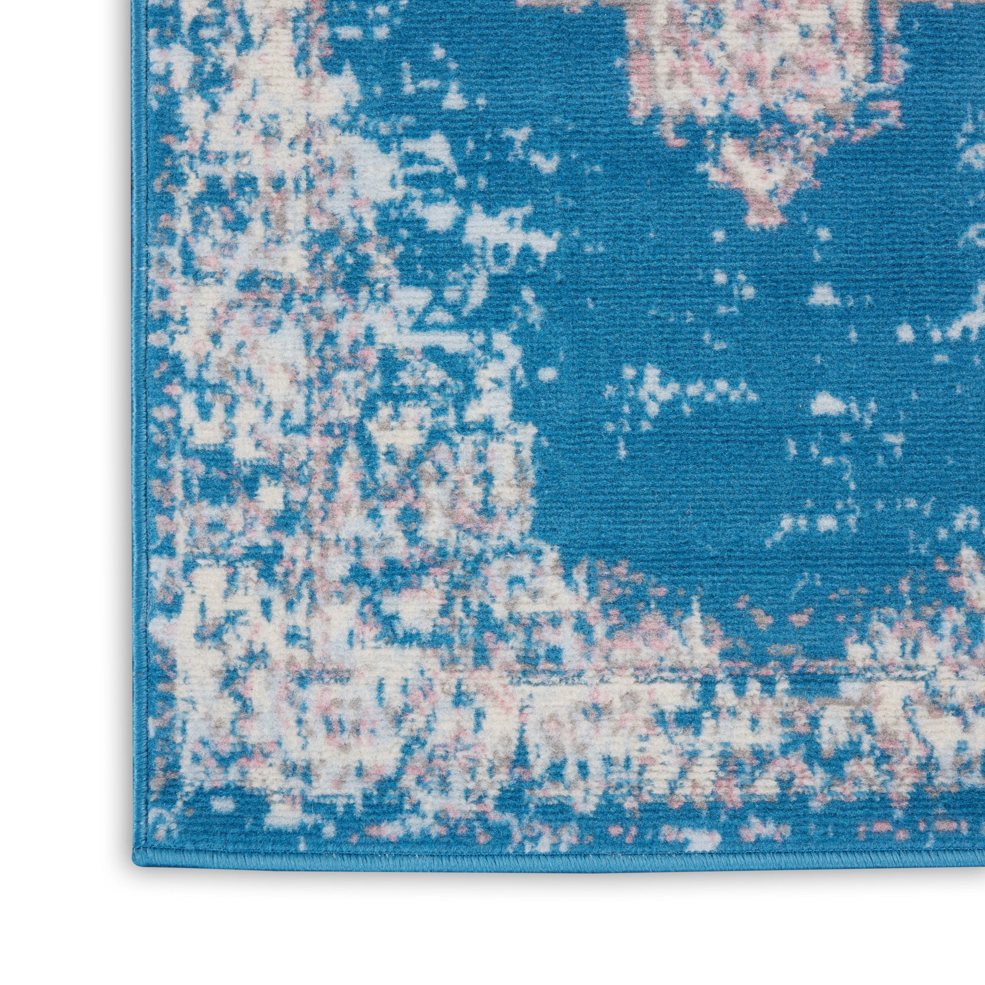 Blue distressed pattern runner rug with cream and pink accents; close-up woven texture and bound edge.