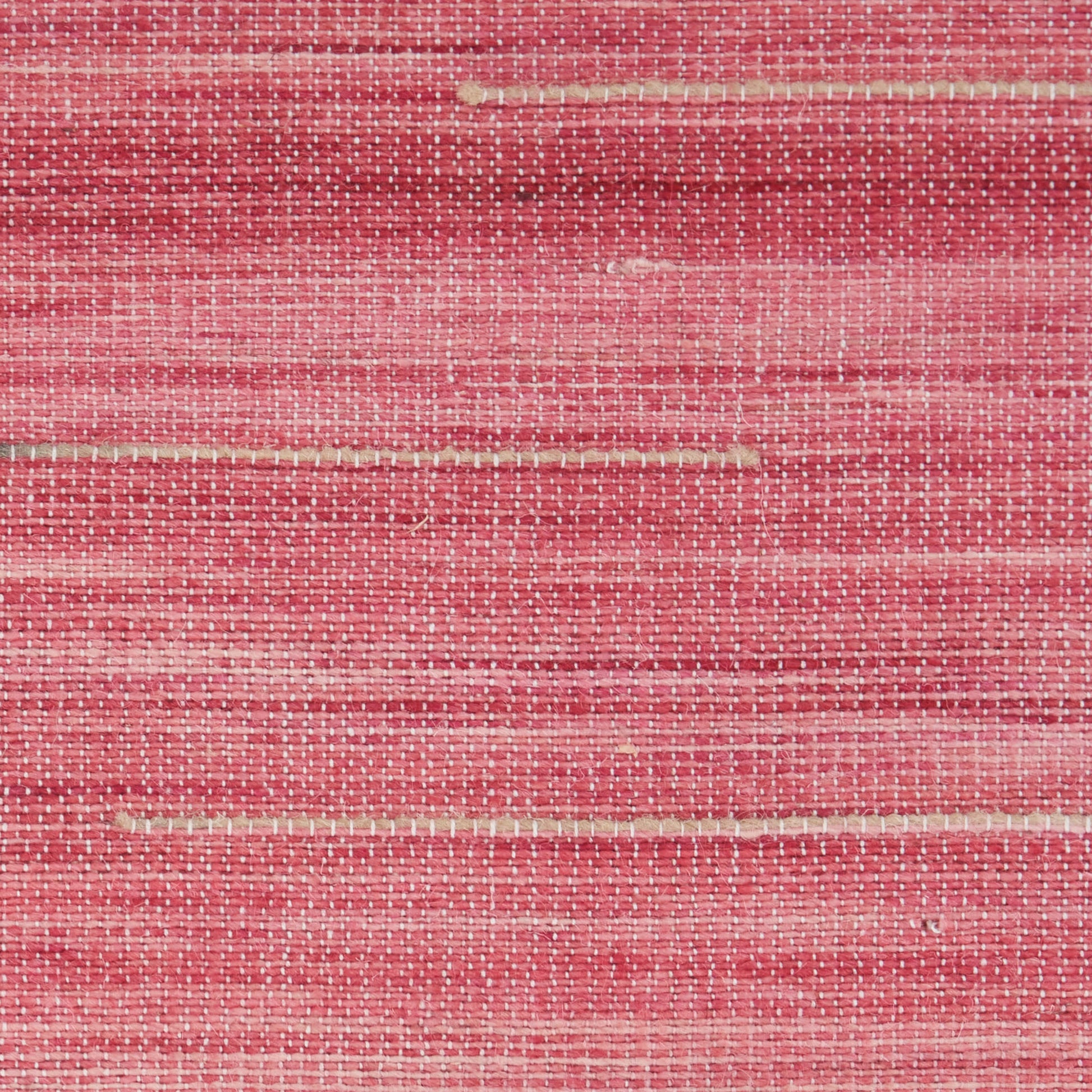 Close-up of pink woven rug with beige horizontal stripes; textured surface.