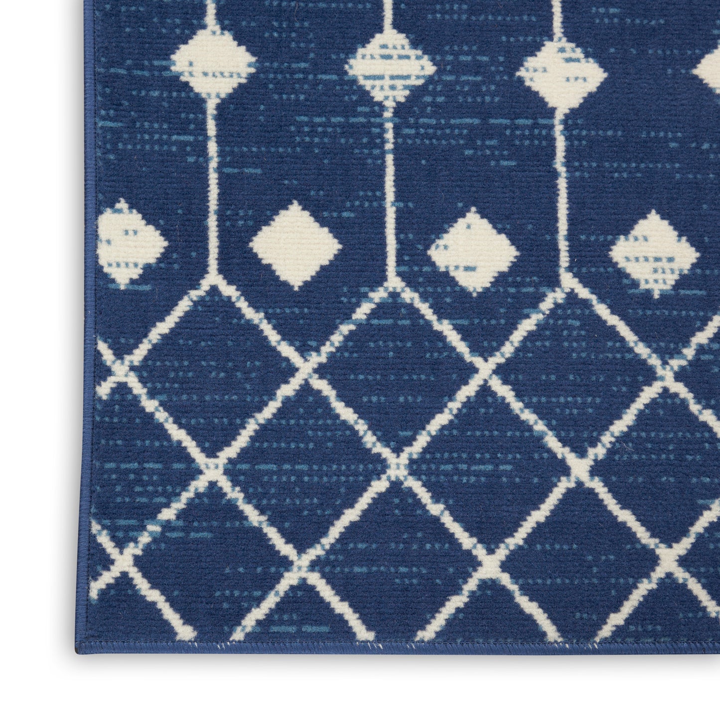Navy blue woven runner rug with white lattice diamond pattern and small diamond accents.