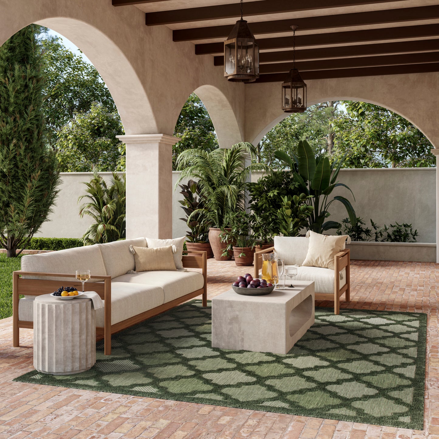 Outdoor seating with cream cushions on wooden-framed sofas, concrete coffee table, and a green rug under arches.