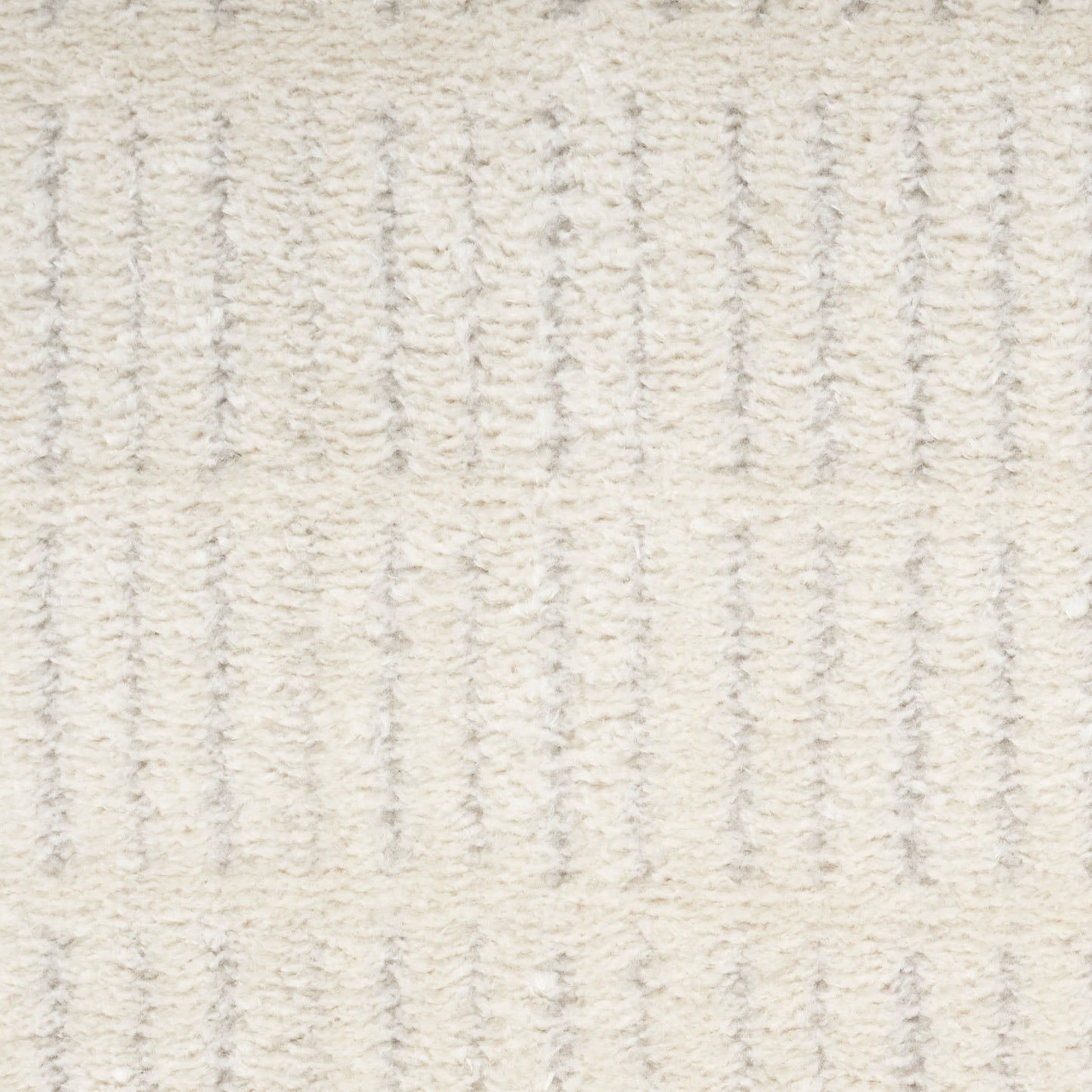 Cream textured rug with vertical ribbed pattern & plush pile for a cozy neutral living space.