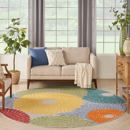 Round multicolor rug with yellow, blue, green and orange circles under a beige sofa with blue and cream cushions.