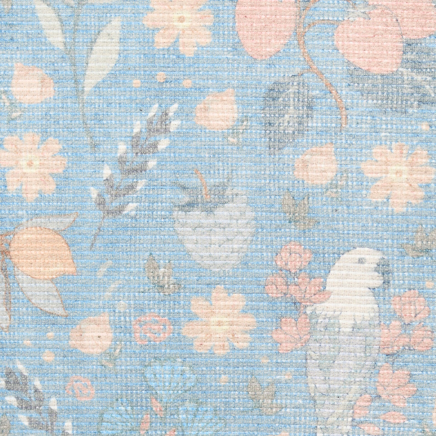 Pastel blue woven rug with peach blossoms, pale leaves, & a white bird motif.