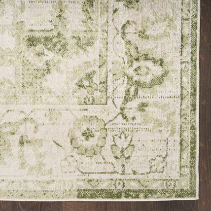 Beige and sage green floral area rug with decorative border, rectangular, on dark wood floor.