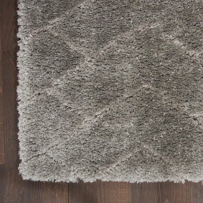 Gray shag rug with long plush pile on dark wood floor; corner edge visible.