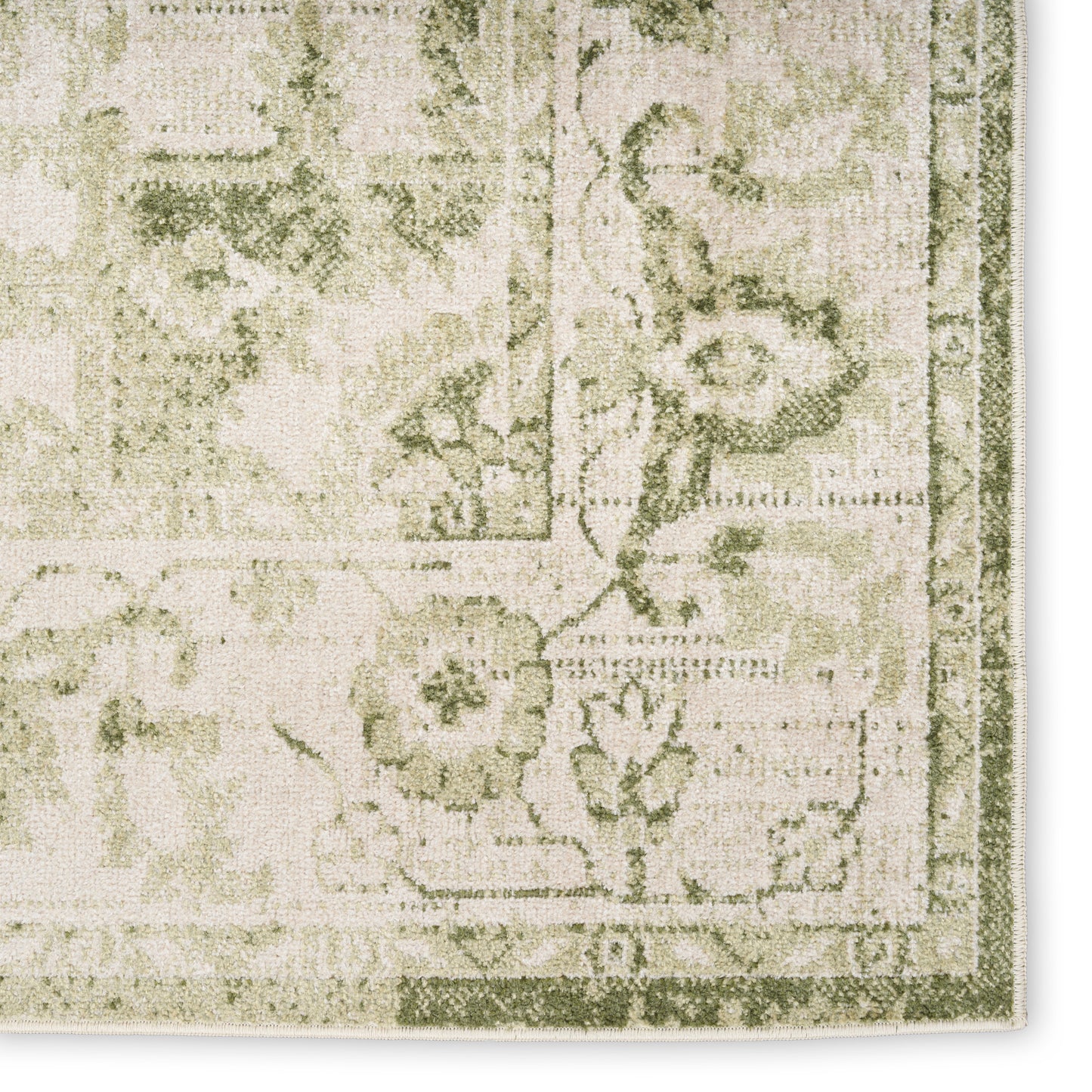 Beige and sage green vintage-style rug close-up with floral pattern and decorative border.