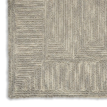 Soft beige and cream tufted rug with geometric rectangular patchwork and a plush, looped pile.