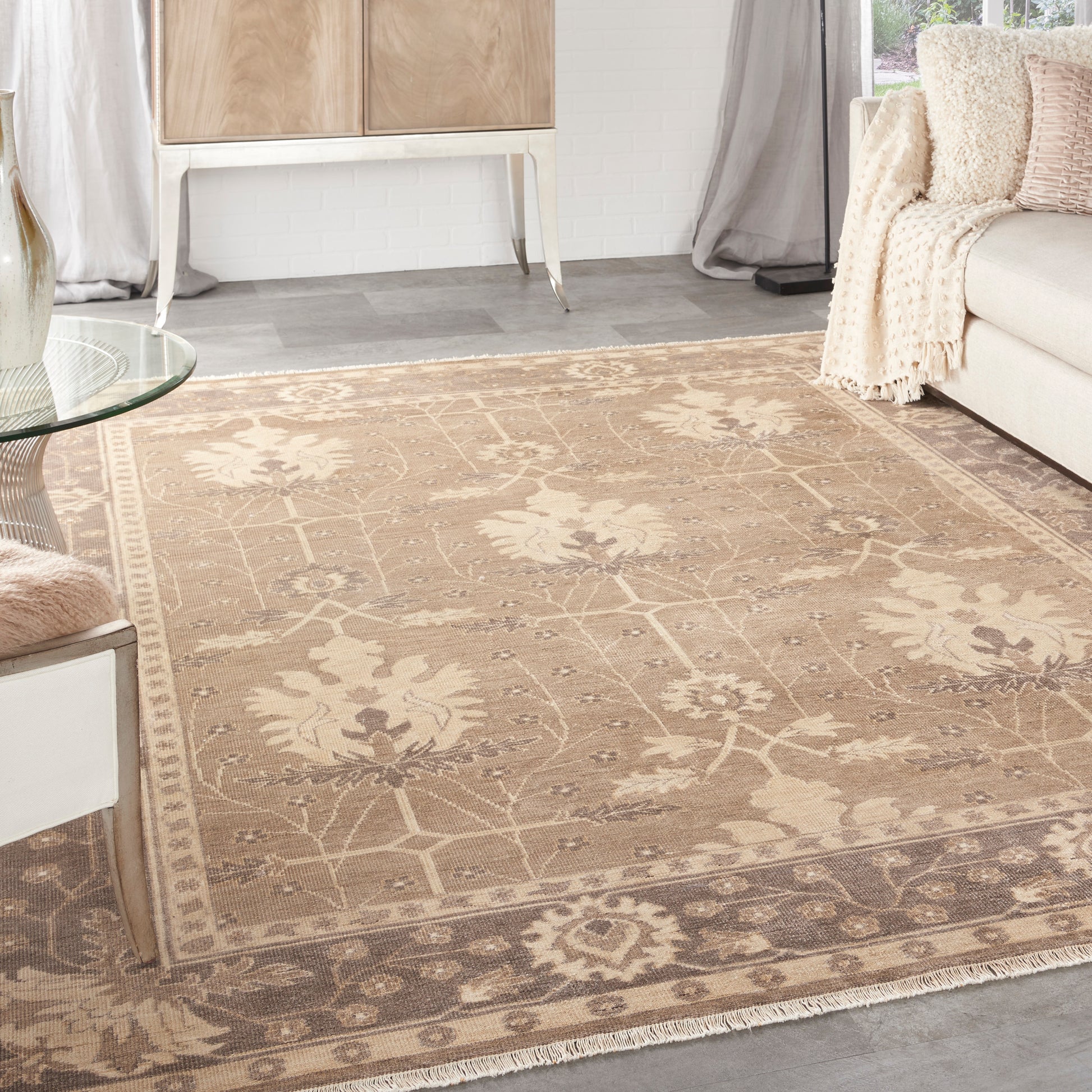Beige floral oriental area rug with cream and taupe motifs and decorative border in a modern living room.